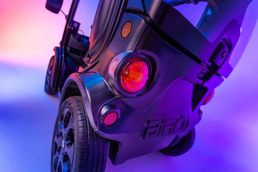 BIRO Big Fast – voiture sans permis électrique – détail roue et carrosserie, ambiance néon