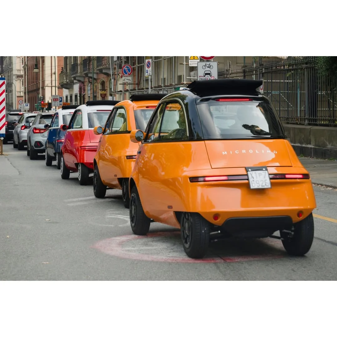 MICROLINO – voiture électrique permis B1 – orange en ville, vue de trois quarts arrière