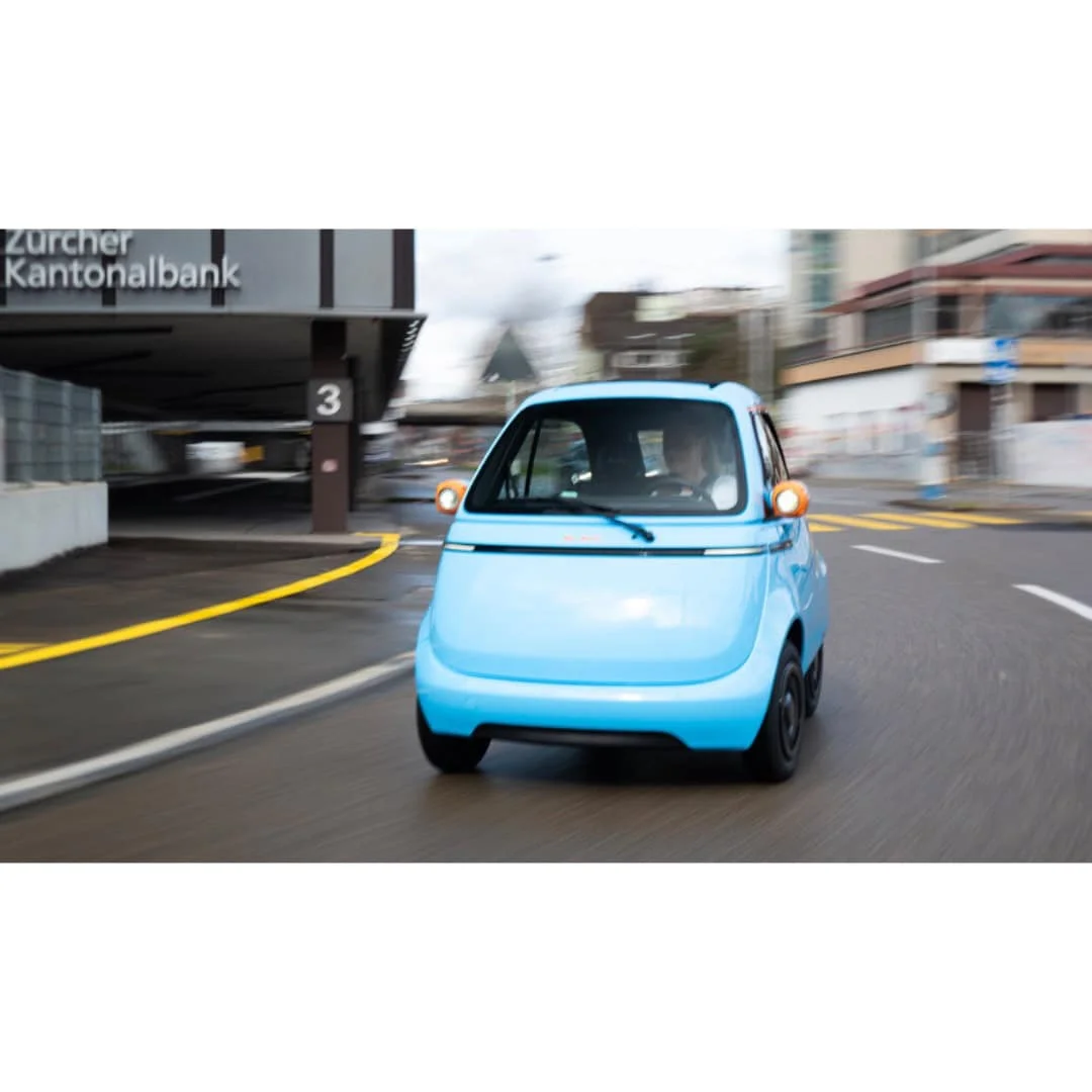 MICROLINO Lite bleue – voiture électrique sans permis – en ville, vue de trois quarts avant