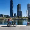 NIU BQi Utility 200 – vélo cargo électrique utilitaire – cycliste devant des immeubles